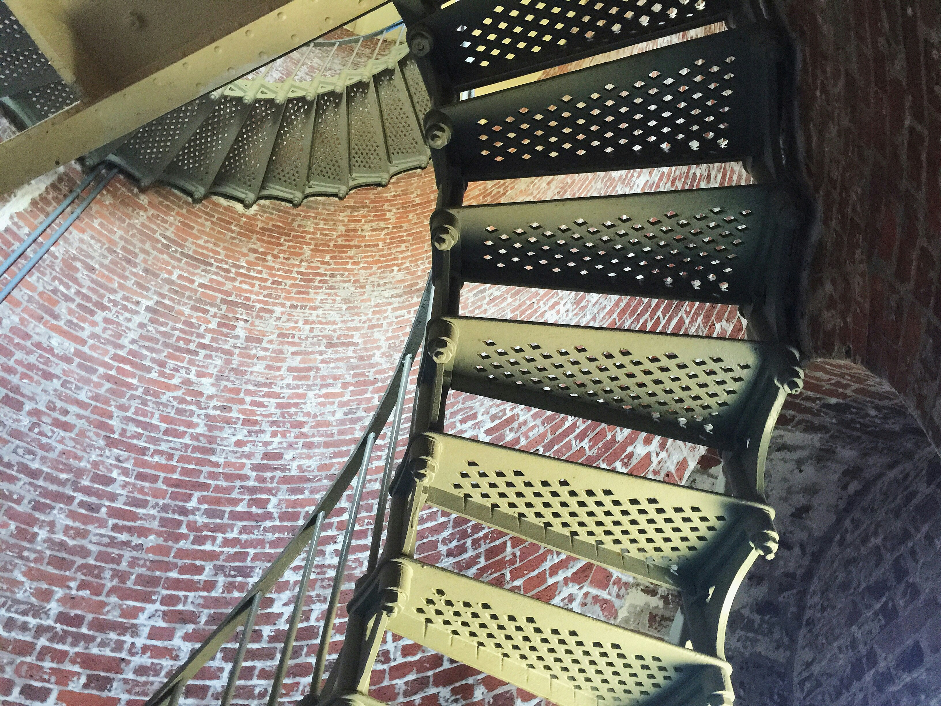 brown wooden spiral staircase with black metal railings